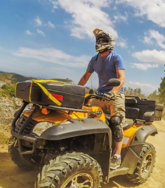 Person riding an ATV bike on rugged adventure trail