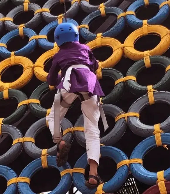 Child enjoying tyre climbing activity at adventure park