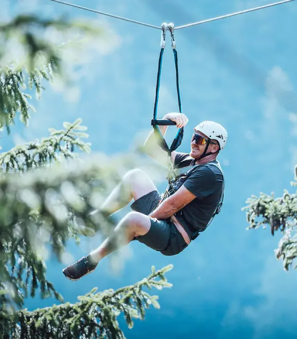 Person gliding on a high zipline at adventure park