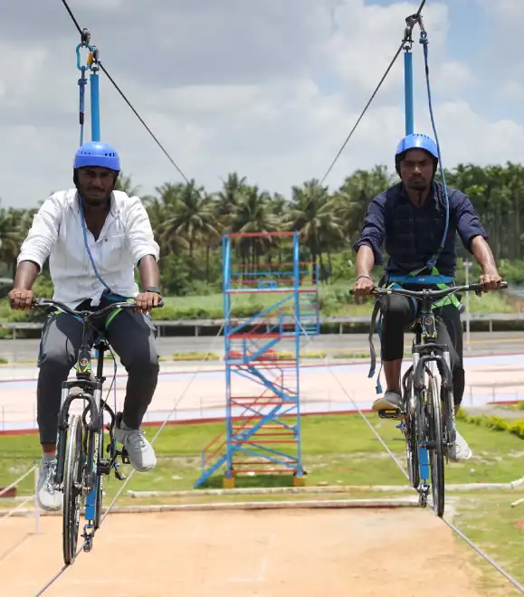 Couple riding sky cycle suspended in mid-air